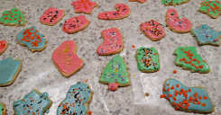 A photo of dairy-free Christmas cookies in multiple colors, shapes, with sprinkles on top